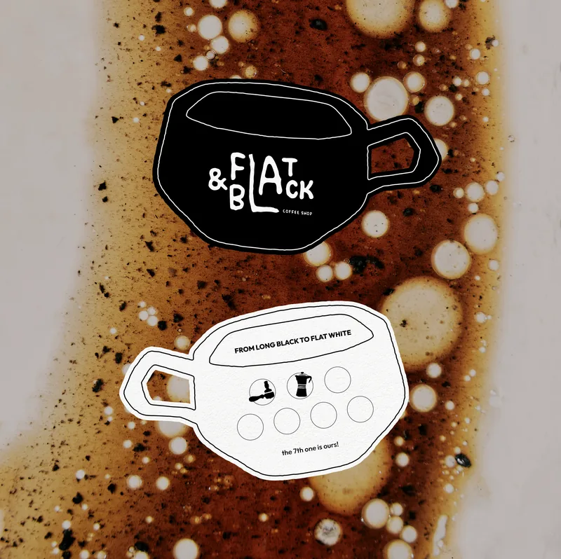 Two cup-shaped loyalty cards on a spill of coffee: one black with the wordmark, one white reading From long black to flat white, with six circles to stamp and the line the 7th one is ours.