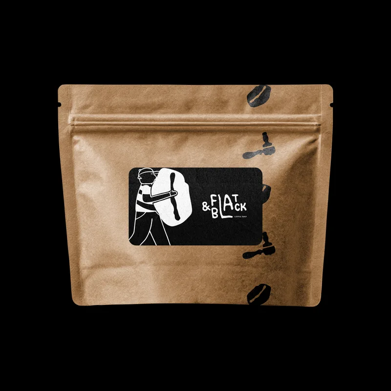 A kraft coffee pouch with a black label — the carrier and the wordmark — on a black ground, with beans printed loose across the paper.