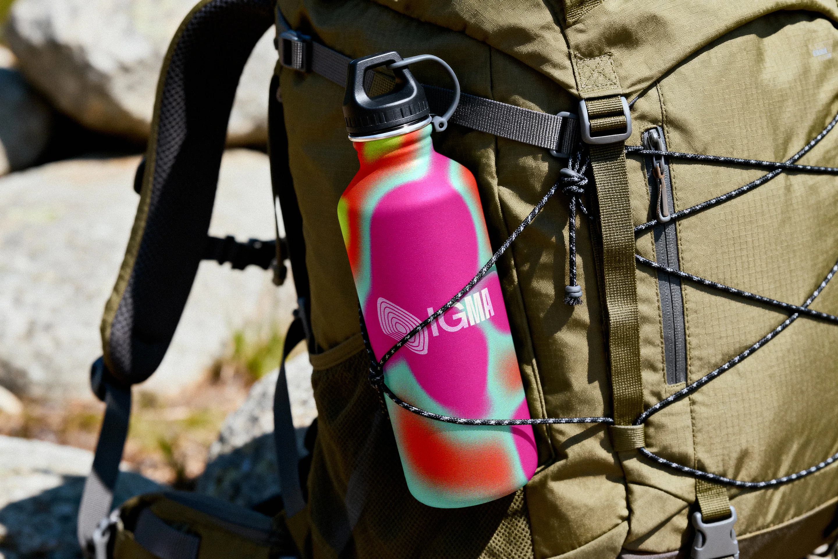 A gradient IGMA flask on a hiking backpack.