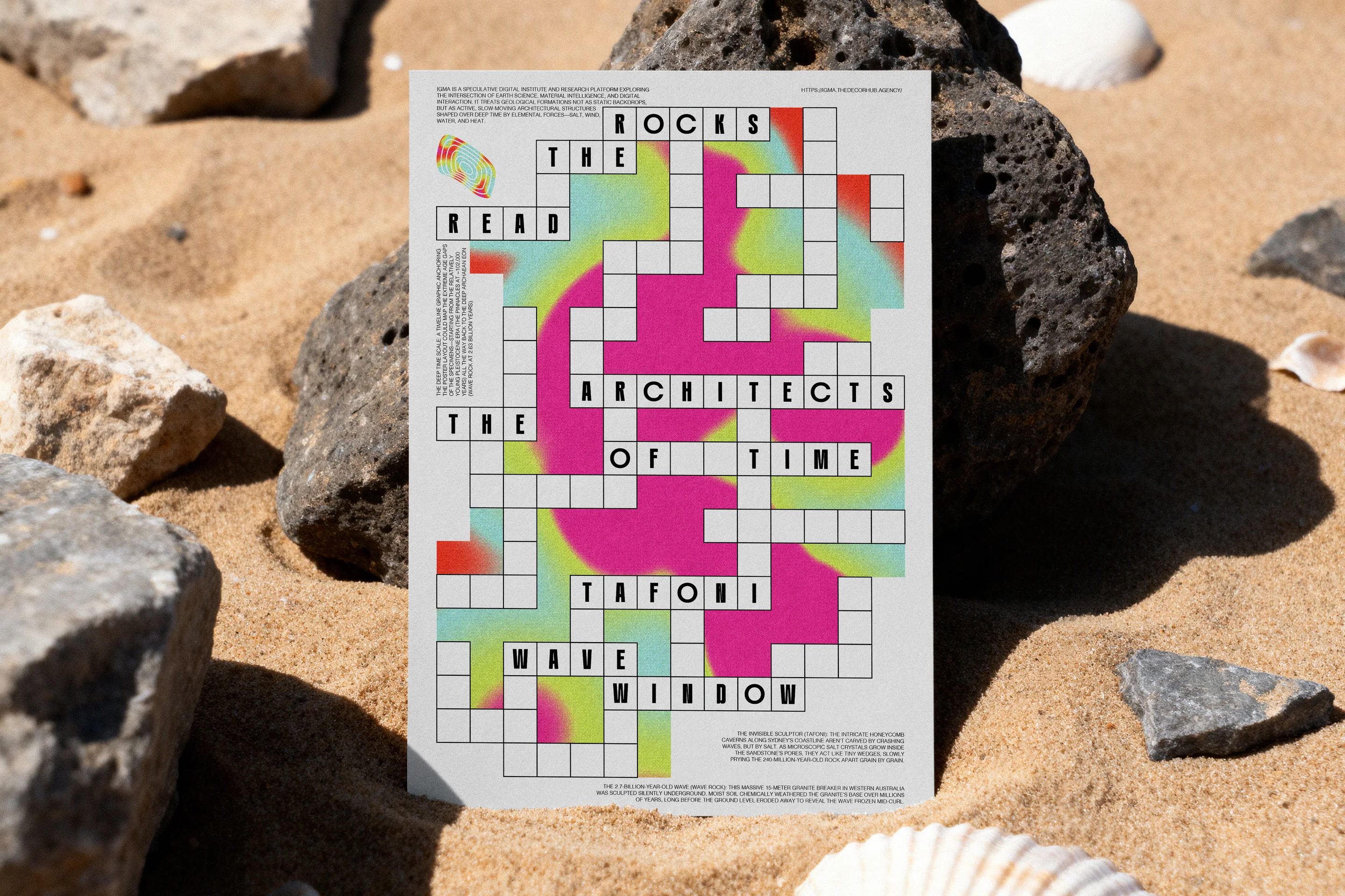 The crossword poster lying on beach sand among dark rocks.