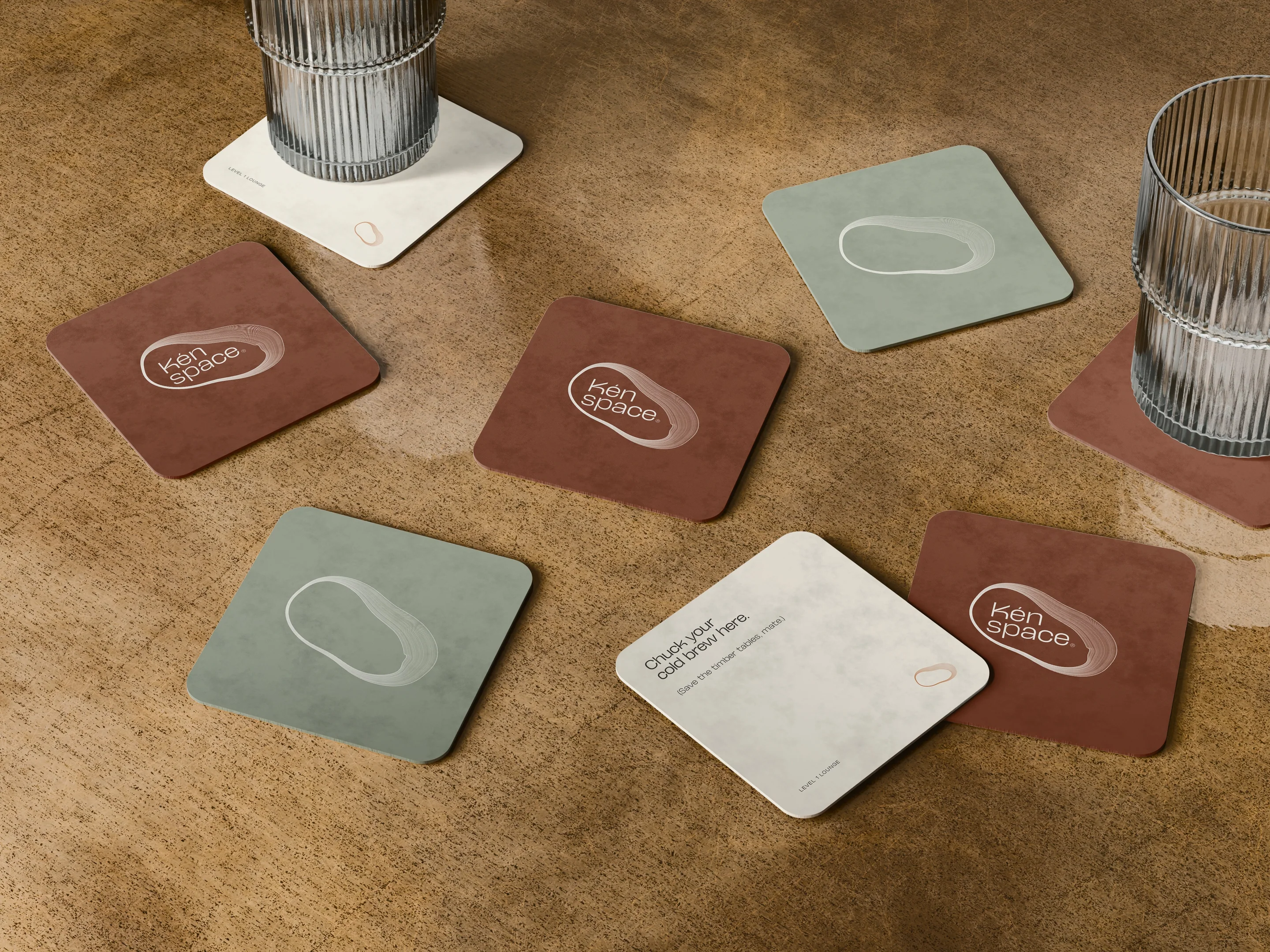 Lounge coasters in copper, sage and cream on a timber table.