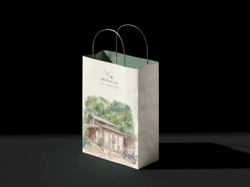 A single paper bag in low light, the watercolour house on its face