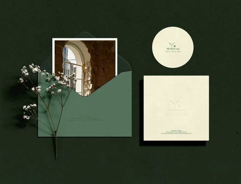 Deep green envelope with the Youth Home sticker, a cream card and baby’s breath flowers