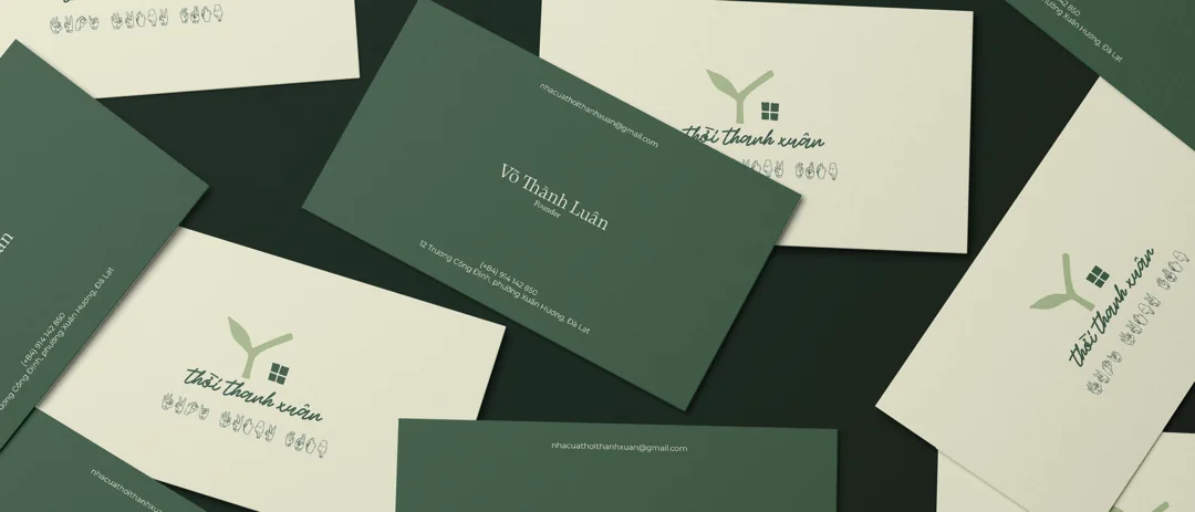 Youth Home business cards scattered — pine green and paper cream, the sprout mark and the founder’s name
