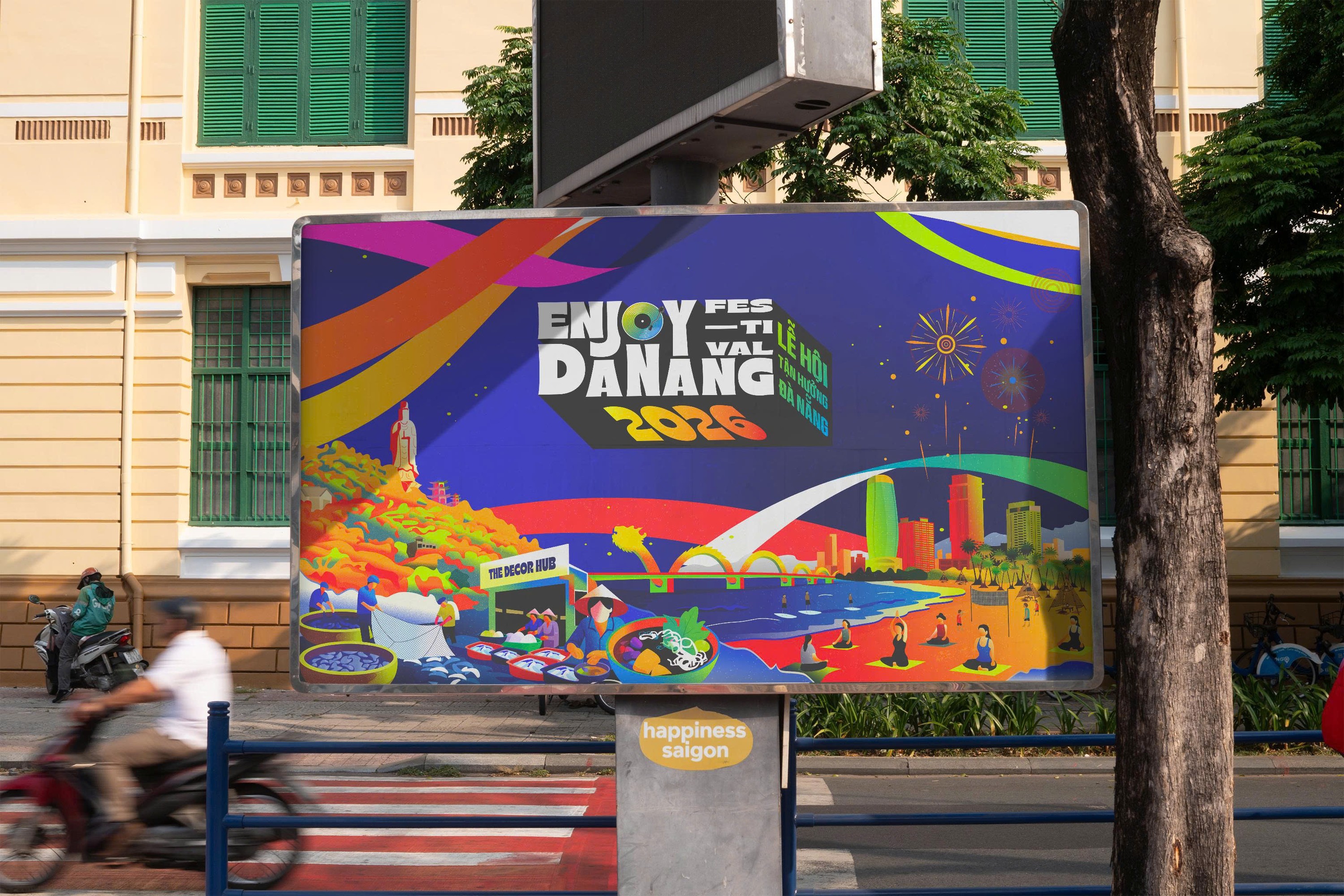 Enjoy Danang billboard on a Da Nang street, motorbike passing.